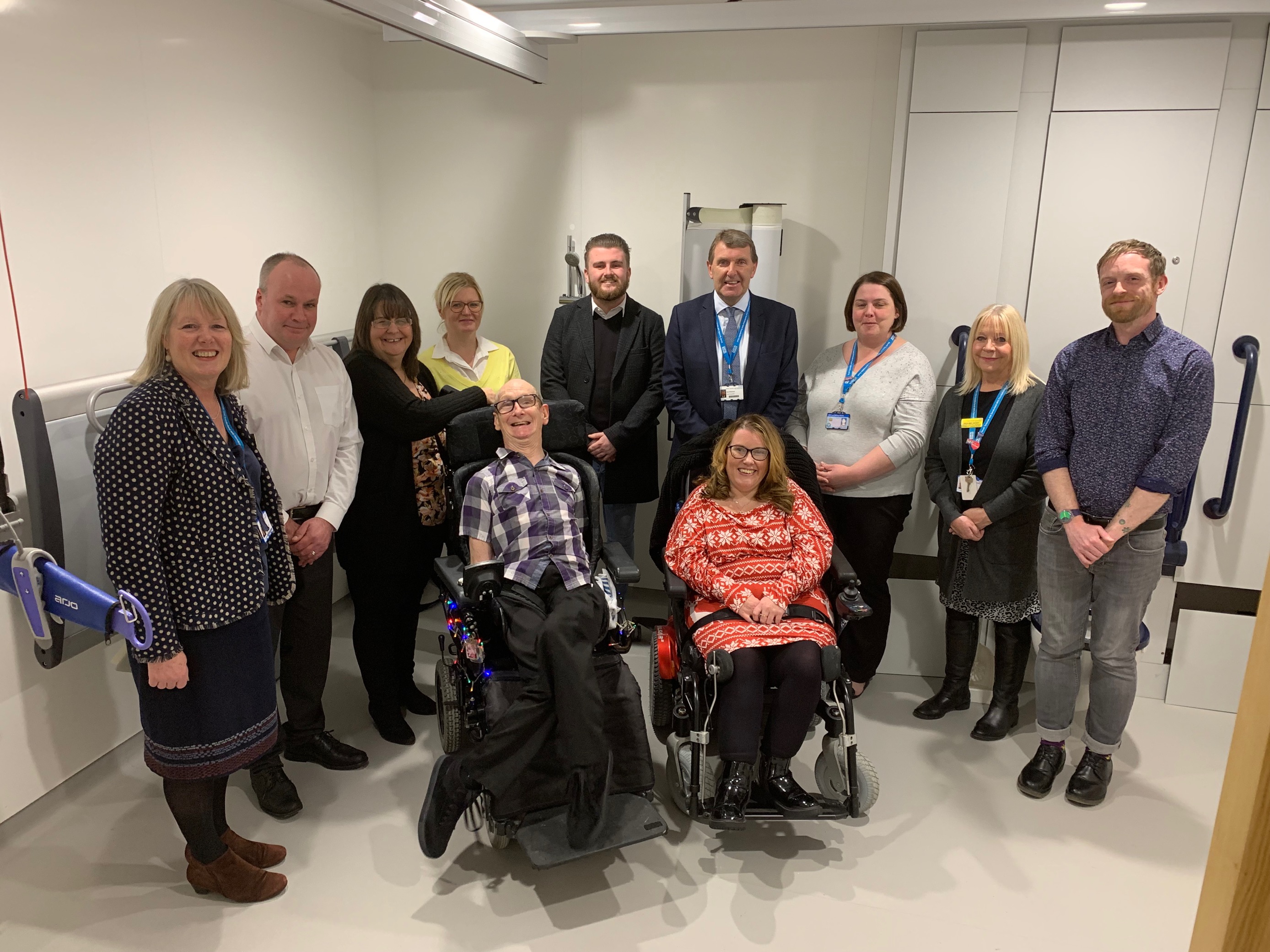Philip Hughes and his sister Karen, standing to the left of him, with Diane Palmer, Deputy Head of Nursing, and Trust Chief Executive Ken Bremner MBE, with representatives of support groups as the room was launched..png