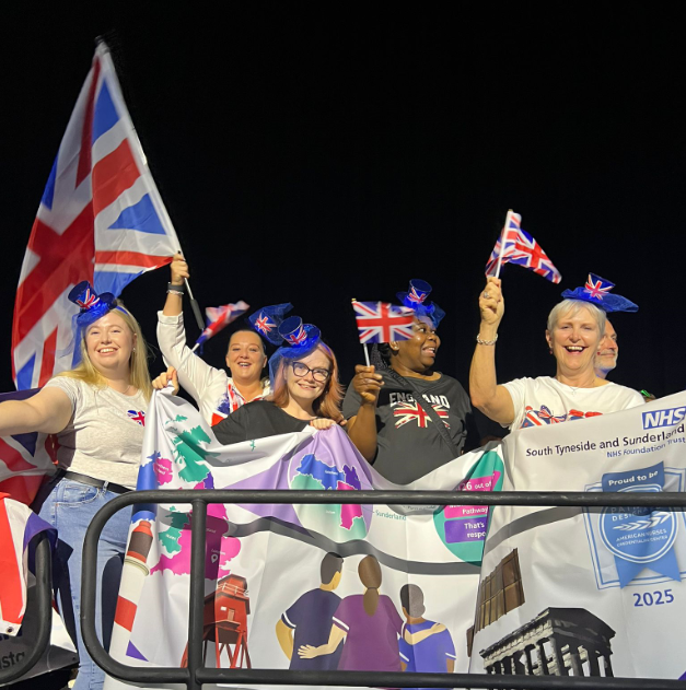 STSFT representatives celebrating their success on the conference stage with Union Jack flags